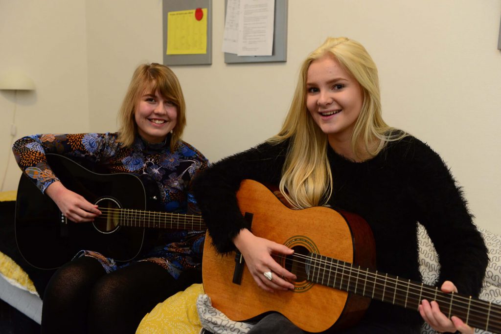 2 Glade elever (piger) der spiller guitar i Musik faget